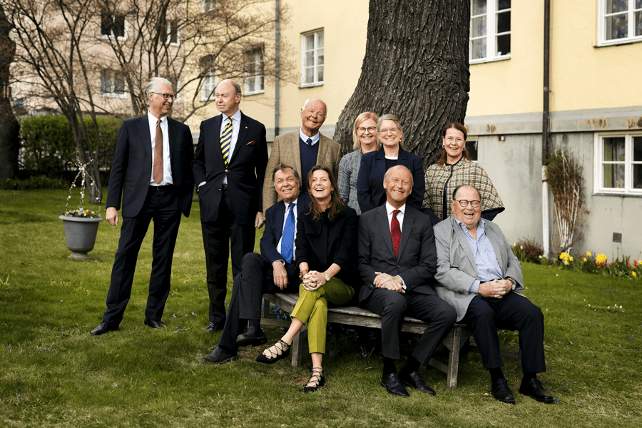 Gruppbild på Stiftelsens Borgerskapets Enkehus och Gubbhus styrelse i en seniorfastighets trädgård, tillhörande Stockholms Borgerskap.