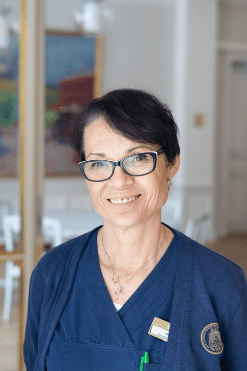 Porträtt av en medarbetare i vårduniform på Borgerskapets vård- och omsorgsboende.