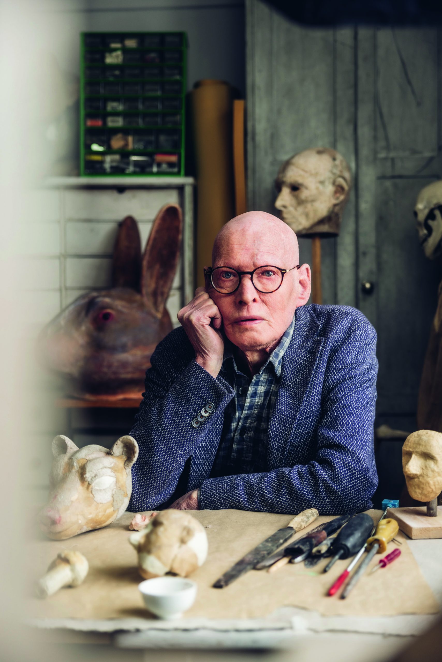 Porträttbild på Arne, omgiven av masker.