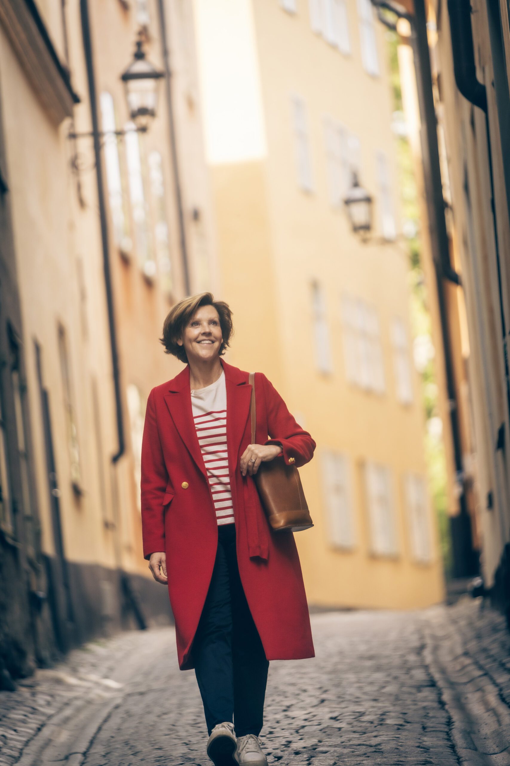 Foto på Lottie som promenerar på en gata i röd kappa